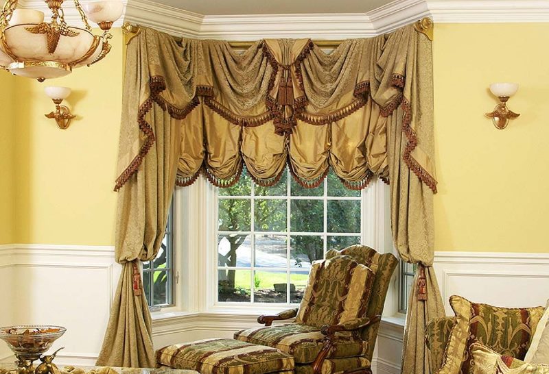 The rich curtains of the Austrian type on the windows of the bay window