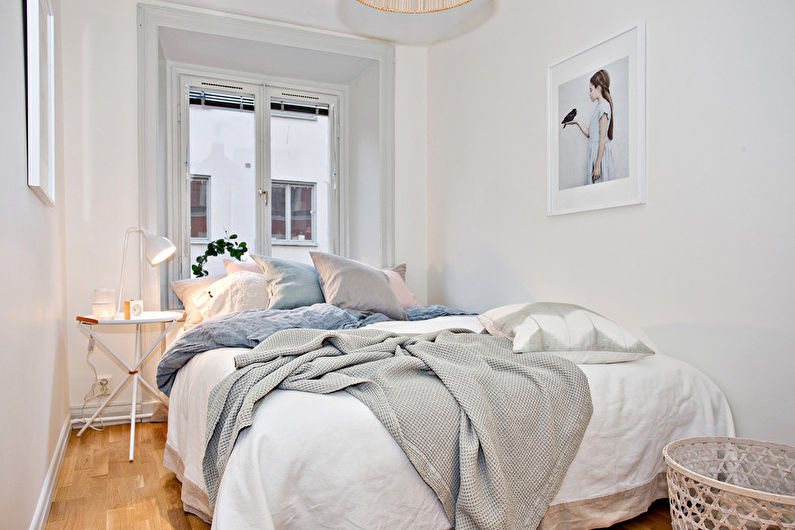 White double bed in the interior of a narrow bedroom