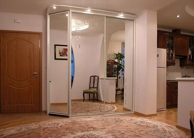 Reflection of the interior of the hallway in the mirrored doors of the wardrobe