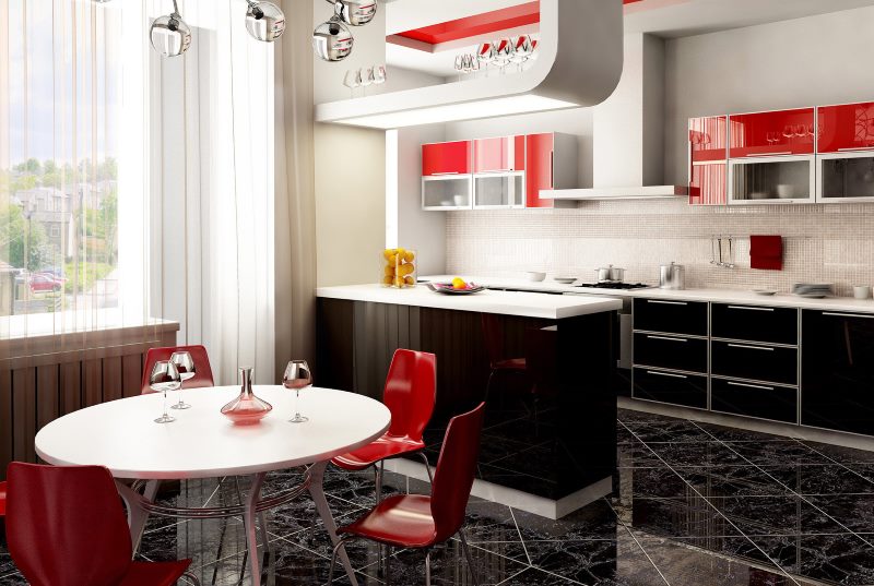 Black and white kitchen with red chairs.