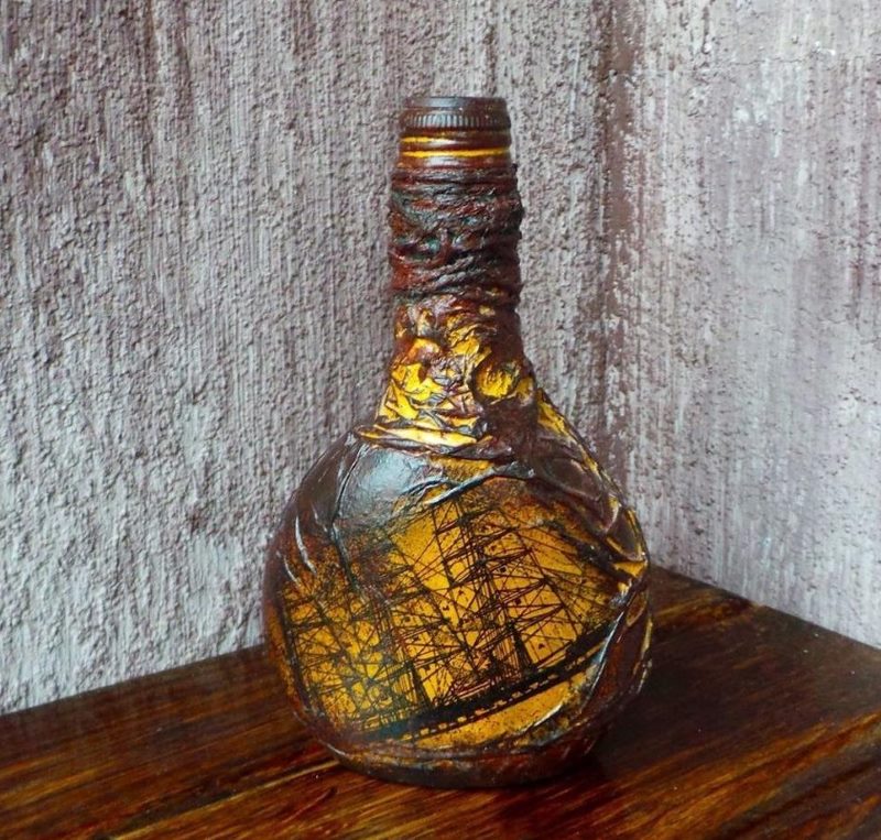 Derlingas burlaivis ant dekoratyvinio butelio