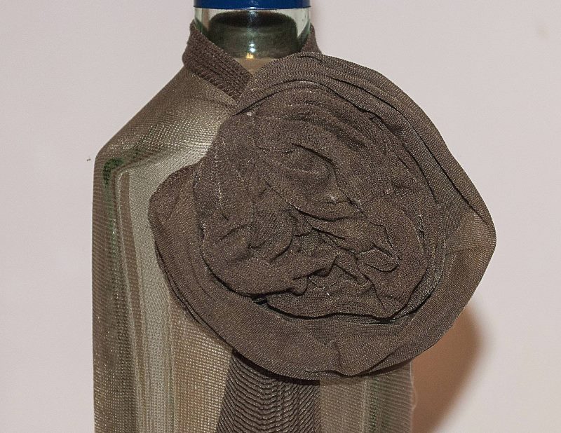 Decorative flower from tights on a glass bottle