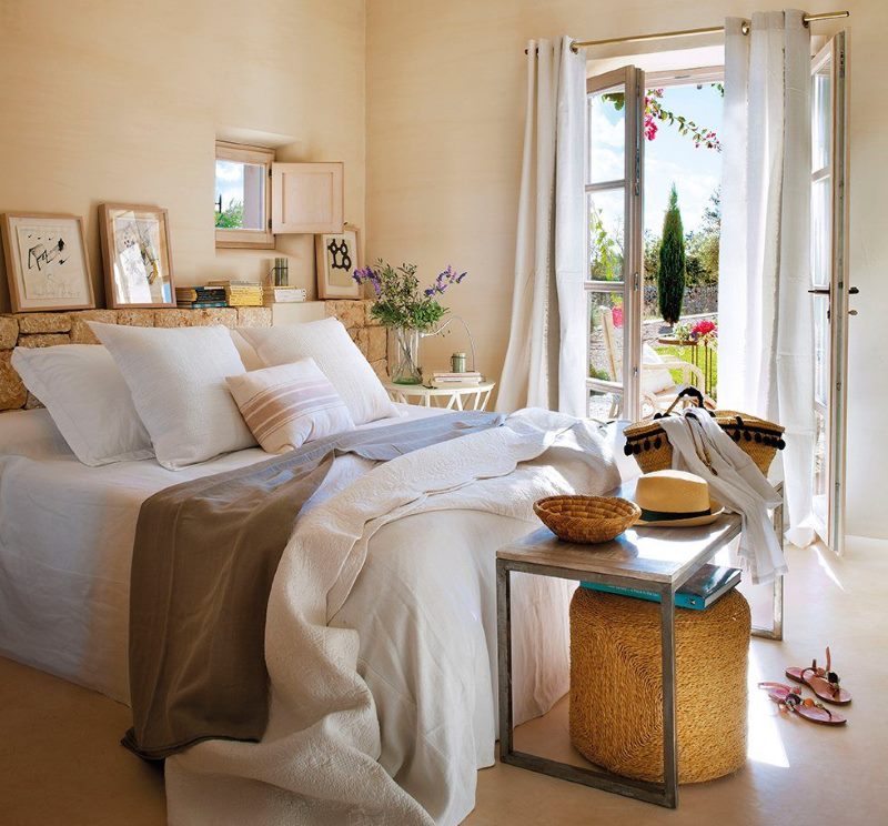 Interior of a bright bedroom with access to the garden of a private house