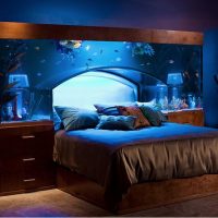 Large aquarium above the bed in the bedroom