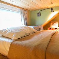 Camera da letto con soffitto basso nell'attico di una casa di campagna