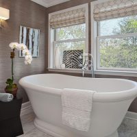 Balta vonia kambaryje su pilkomis sienomis