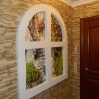 Fenêtre avec une arche sur le mur du couloir dans une maison à panneaux