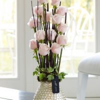 Pale pink flowers in a metal vase