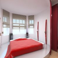 Couvre-lit rouge sur le lit dans une chambre blanche
