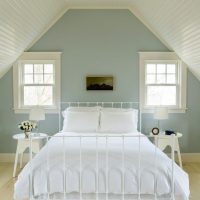 White bed in the attic of a country house