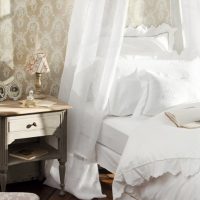 Антична нощна шкафче близо до бяло легло