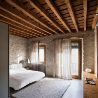 Wooden ceiling in the bedroom with stone walls