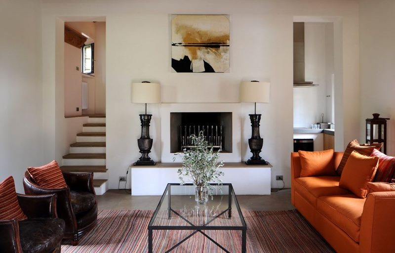 Orange sofa in the living room interior with fireplace