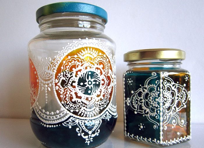 Two cans with an interesting ornament on glass