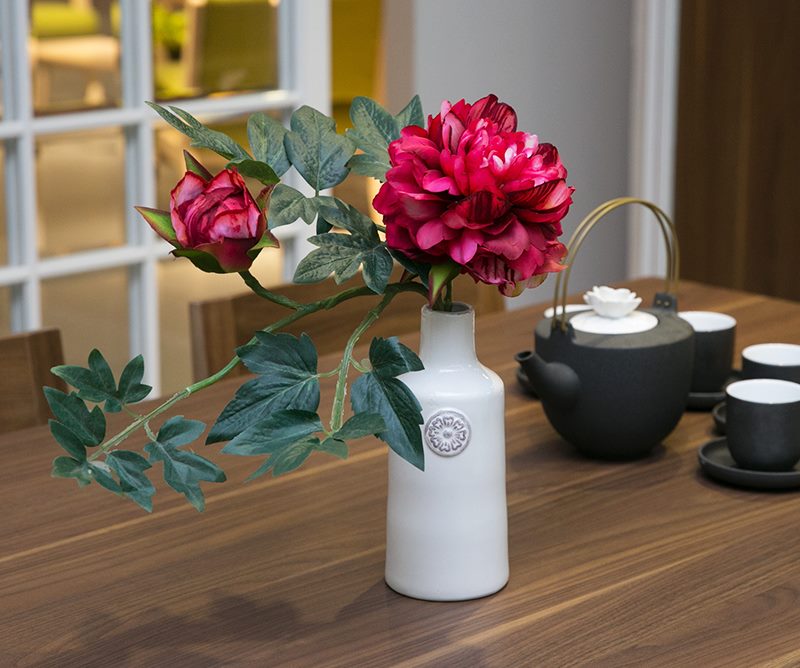 Artificial plastic peonies on the dining table