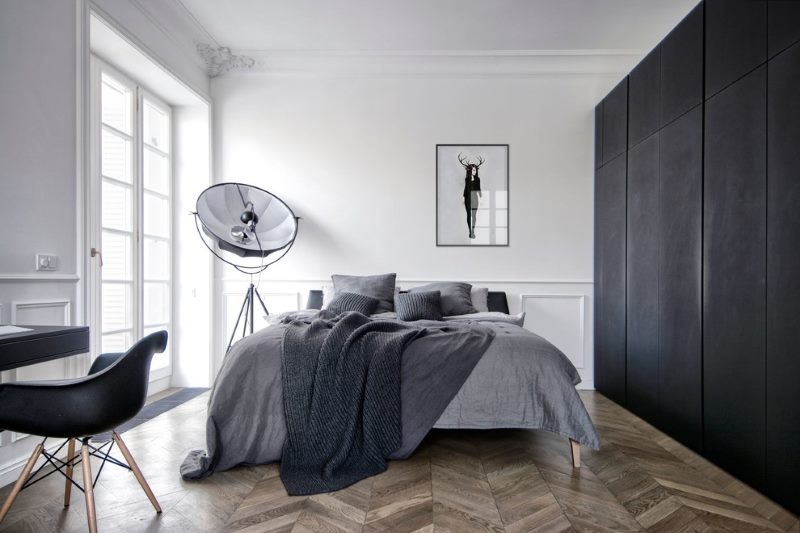 Black wardrobe in the bedroom with white walls.