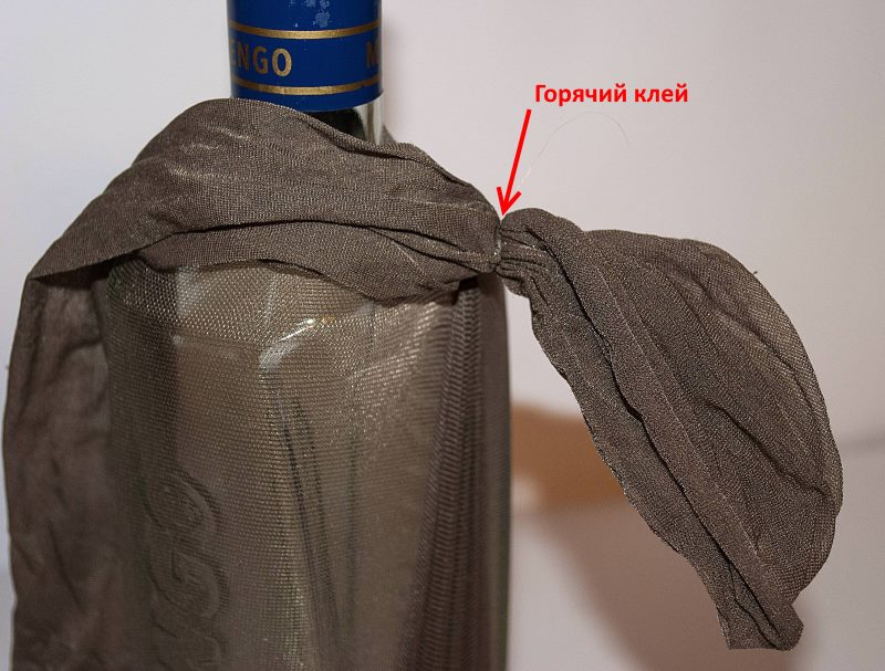 Using hot glue to decorate a bottle