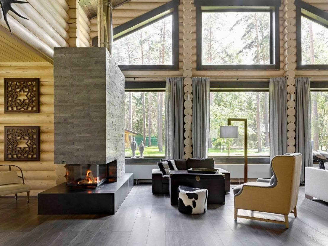 Modern fireplace in the interior of the living room of a log house