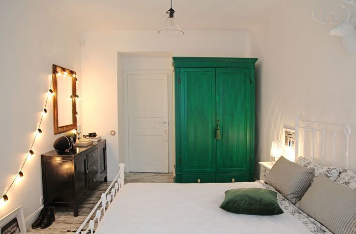 Bright bedroom interior with green wardrobe
