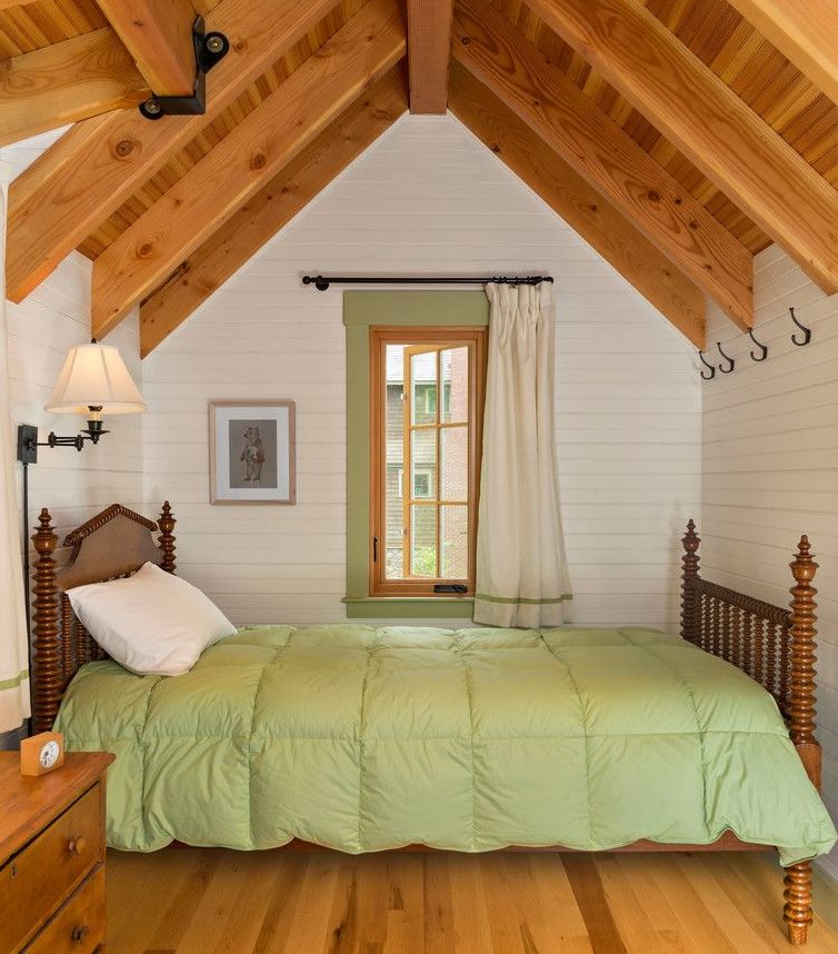 Interior of a small bedroom in the attic of a wooden house