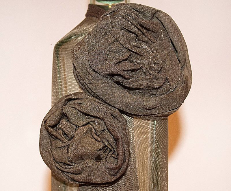 Two roses from old tights on a bottle