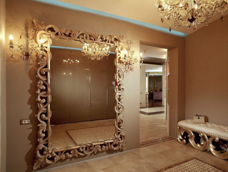 Specchio in una cornice con riccioli sul muro del corridoio