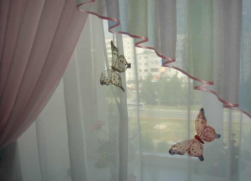 Decorative butterflies on curtains in a girl's bedroom