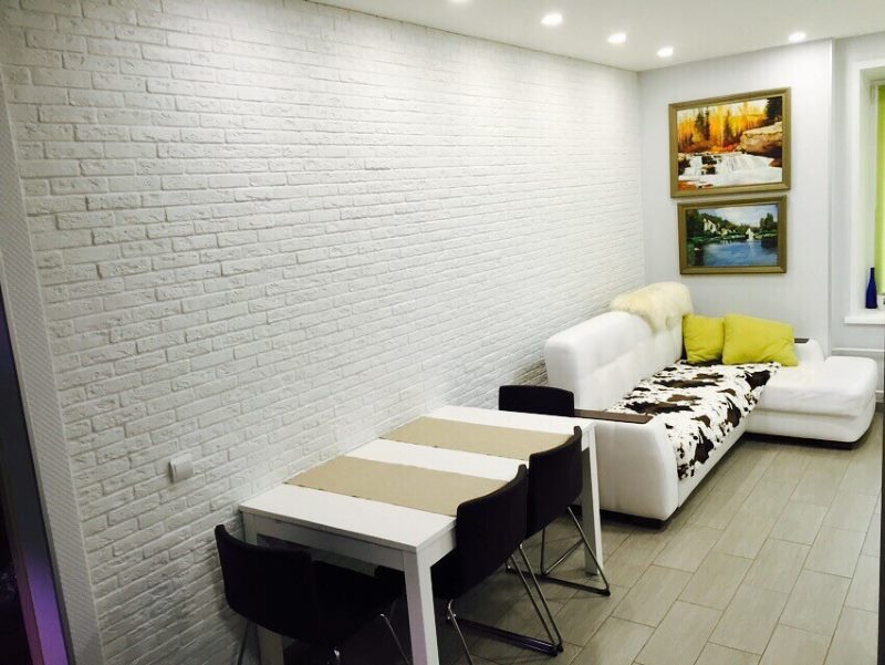 White brick wall in the interior of the kitchen-living room