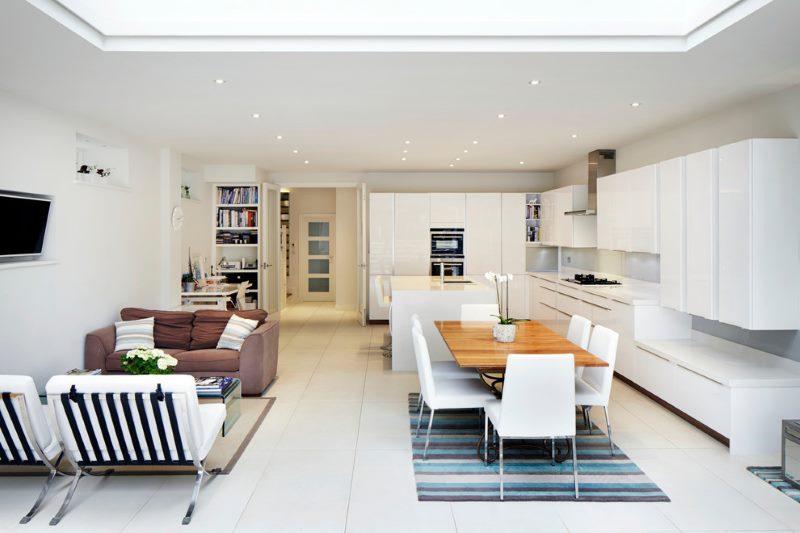 Design of a spacious kitchen-living room with a white set