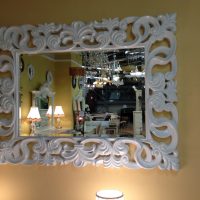 Cadre blanc sculpté sur le miroir