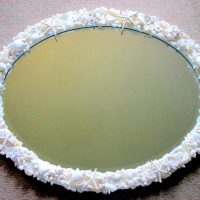 Ovalus veidrodis mažų kriauklių rėmelyje