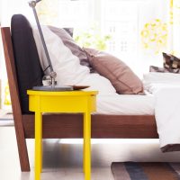Yellow chair in front of the bed in the bedroom