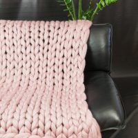 Knitted cloak on a leather sofa