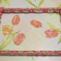 Simple photo frame of twigs and ribbons