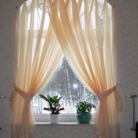 Light beige curtains on an arched window