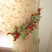 Artificial leaves with berries on a beige curtain