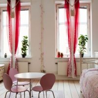Pink curtains on the windows of a studio apartment