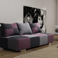 Sofa with three-color upholstery in the living room of a panel house