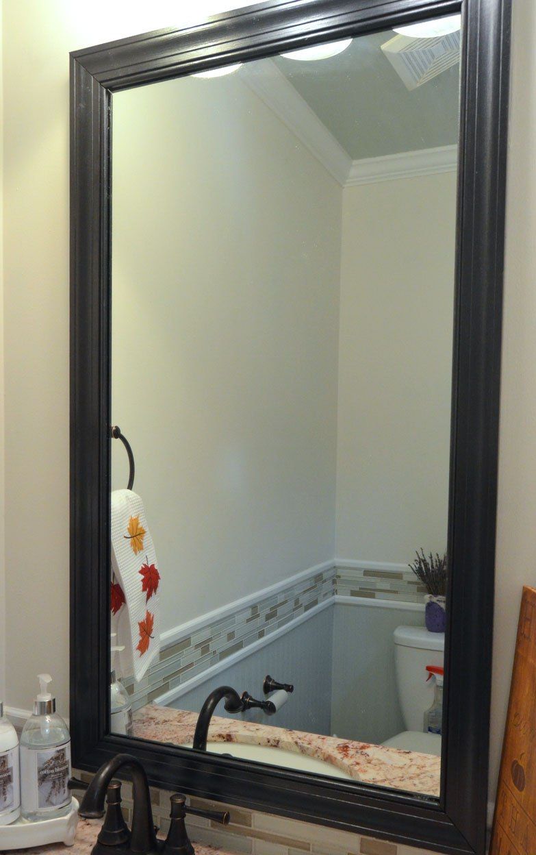 Juodas grindjuostės rėmas ant vonios veidrodžio