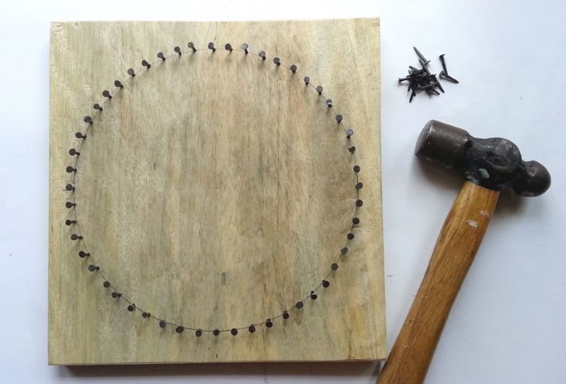 Create a picture on a board with nails and threads