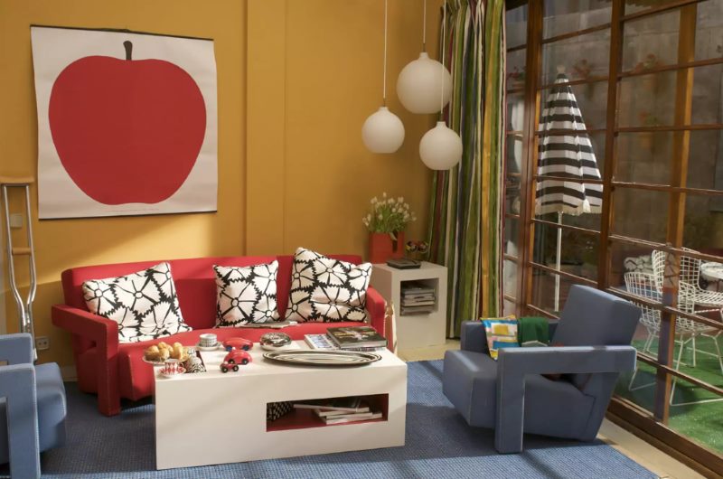 Dipingere con una grande mela sulla parete arancione del soggiorno