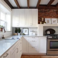 Wooden beams on the white ceiling of the kitchen