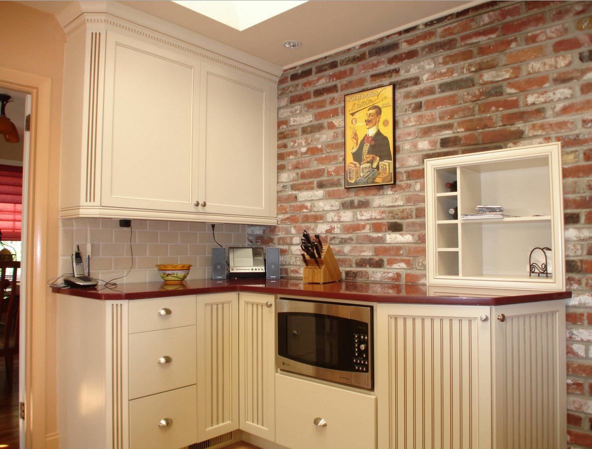 Corner kitchen with brick wall.