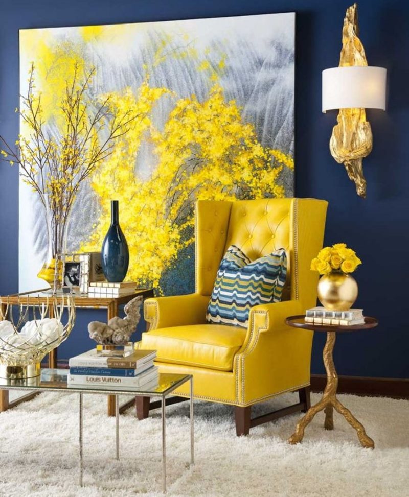 Fauteuil jaune contre un mur bleu avec une photo