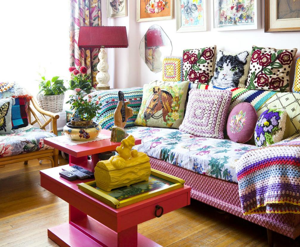 Oreillers variés sur un canapé avec une couverture colorée