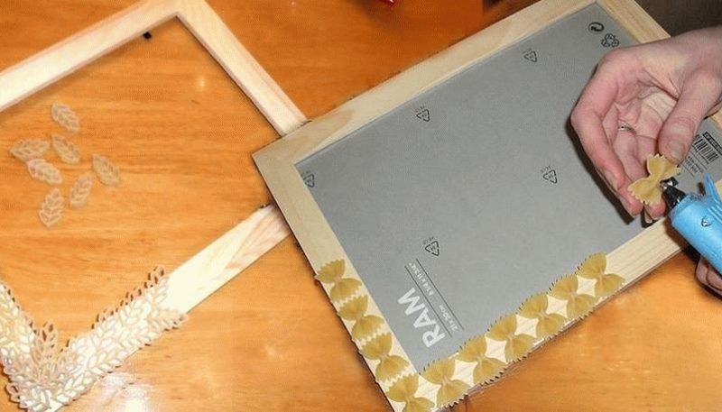 Sticking pasta on a wooden picture frame