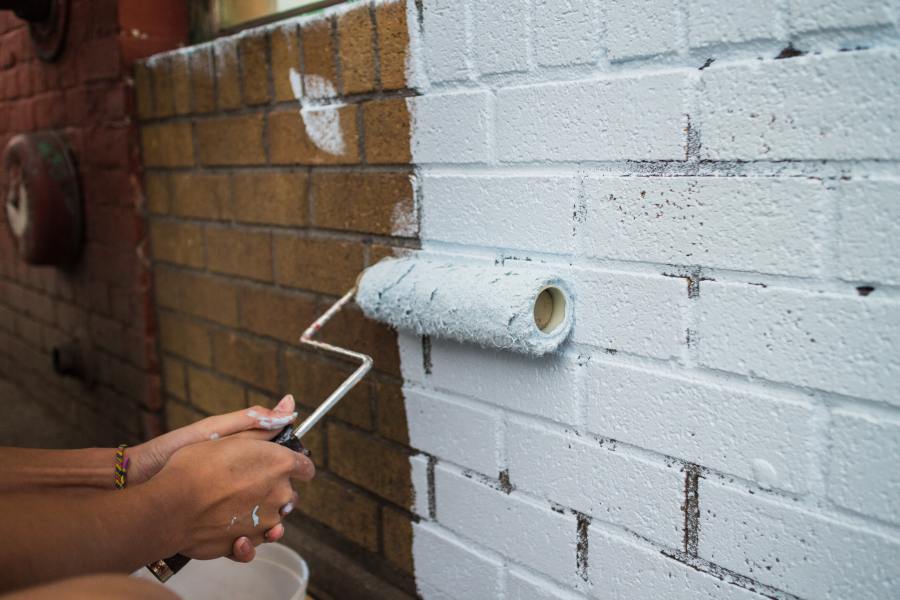Painting a brick wall with a paint roller