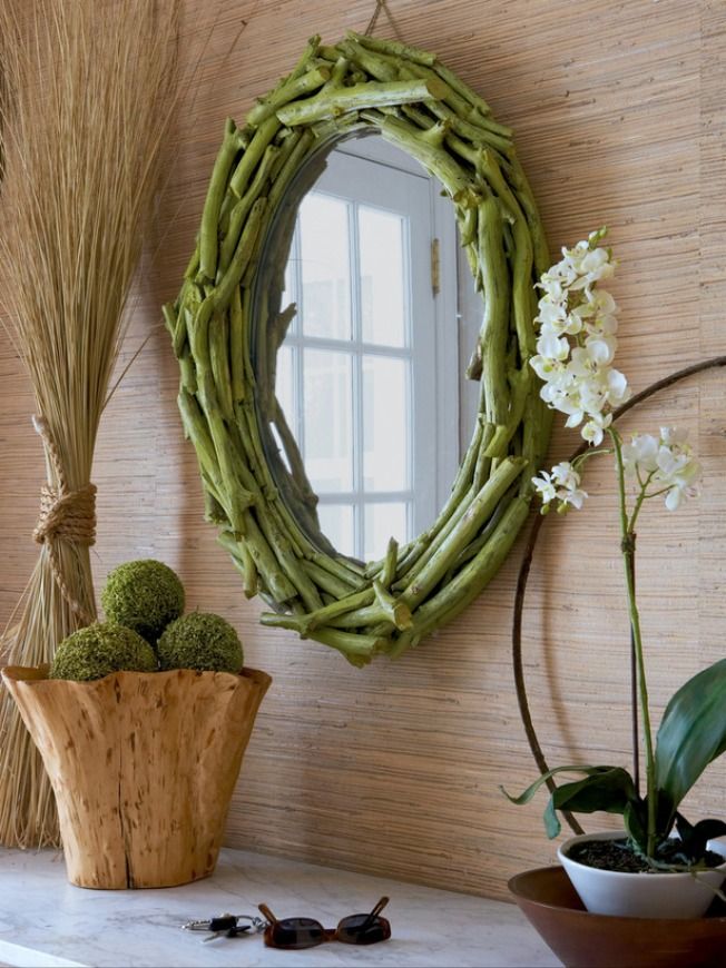 Homemade frame from branches on an oval mirror