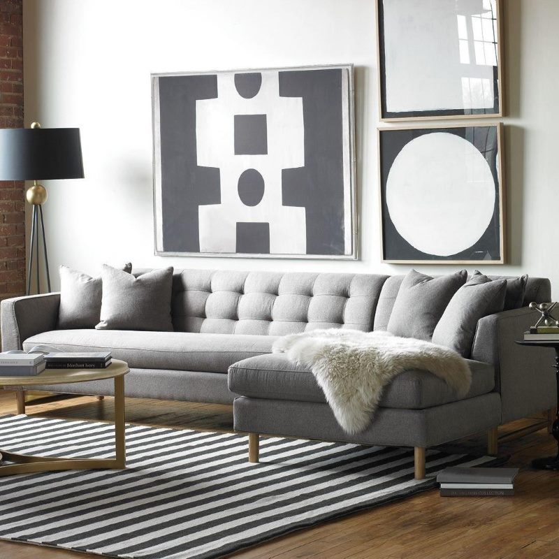 Pelliccia mantello su un divano grigio in un piccolo soggiorno