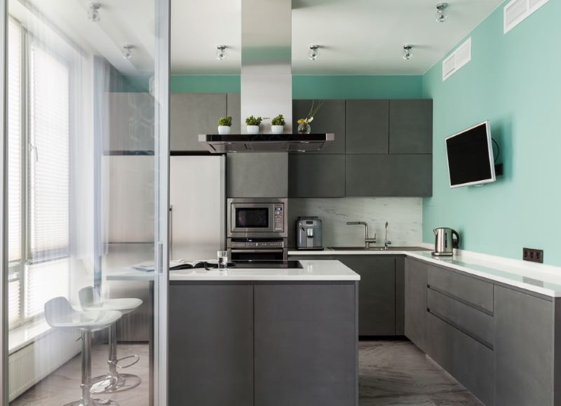 Mur turquoise dans la cuisine avec un set gris